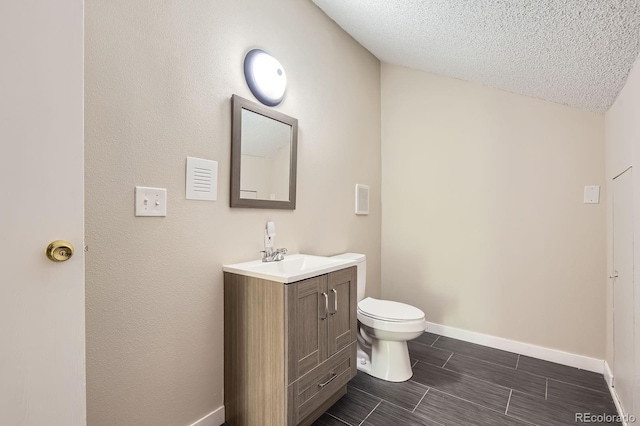 3539 S Fairplay Way Unit 10, Aurora, CO 80014 - bathroom with vanity, toilet, baseboards, a textured ceiling, and wood finish floors