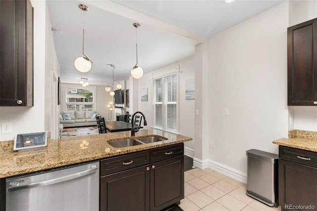 kitchen featuring stainless steel dishwasher, pendant lighting, light stone countertops, and sink