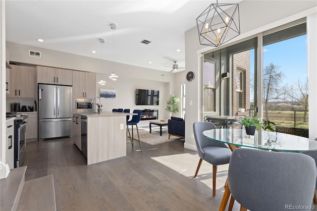 5026 S Platte River Pkwy, Littleton, CO 80123 - kitchen with appliances with stainless steel finishes, modern cabinets, a breakfast bar area, healthy amount of natural light, and recessed lighting