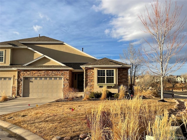 view of front of home featuring stone siding, driveway, and stucco siding