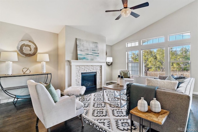 living area with a brick fireplace, a ceiling fan, baseboards, and dark wood-type flooring