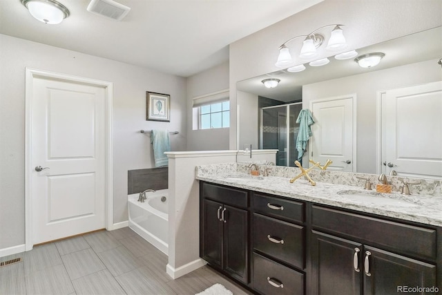 bathroom featuring a stall shower, visible vents, a sink, and a garden tub