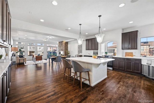 kitchen featuring a center island, dark wood-type flooring, and dark brown cabinets