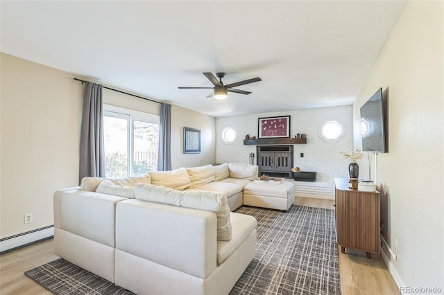 3730 Applewood St, Grand Junction, CO 81506 - living room with wood finished floors, ceiling fan, a fireplace, and a baseboard heating unit