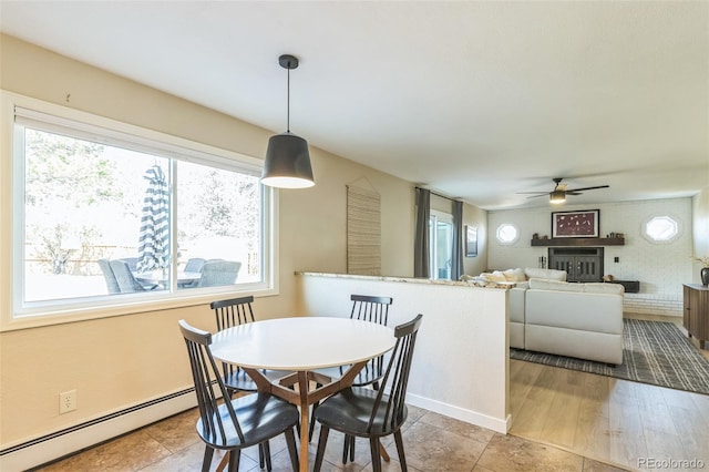 3730 Applewood St, Grand Junction, CO 81506 - dining space featuring baseboards, a ceiling fan, a baseboard heating unit, and a fireplace