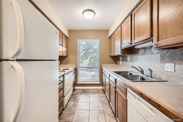 kitchen with decorative backsplash, sink, light tile patterned flooring, a textured ceiling, and white appliances