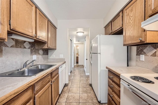 kitchen featuring white appliances, light tile patterned floors, tasteful backsplash, and sink