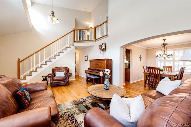 6454 S Nelson Way, Littleton, CO 80127 - living area with a chandelier, wood finished floors, stairway, a towering ceiling, and arched walkways