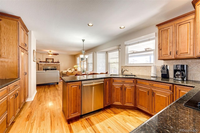 6454 S Nelson Way, Littleton, CO 80127 - kitchen featuring dishwasher, a sink, a fireplace, brown cabinetry, and light wood finished floors