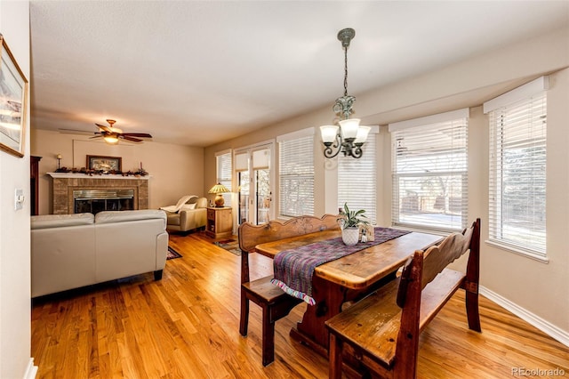 6454 S Nelson Way, Littleton, CO 80127 - dining area featuring a chandelier, light wood finished floors, a ceiling fan, and plenty of natural light