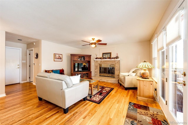 6454 S Nelson Way, Littleton, CO 80127 - living area with a glass covered fireplace, light wood-style floors, and a ceiling fan