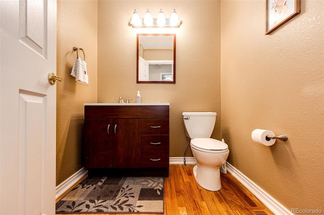 6454 S Nelson Way, Littleton, CO 80127 - bathroom featuring vanity, wood finished floors, toilet, and baseboards