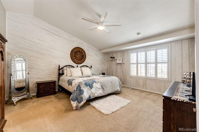 6454 S Nelson Way, Littleton, CO 80127 - bedroom featuring wooden walls, light colored carpet, multiple windows, lofted ceiling, and ceiling fan