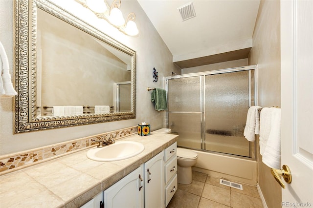 6454 S Nelson Way, Littleton, CO 80127 - full bathroom featuring vanity, toilet, tile patterned flooring, and bath / shower combo with glass door