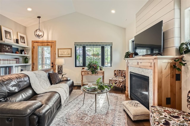 living room with a fireplace, wood finished floors, a notable chandelier, lofted ceiling, and recessed lighting