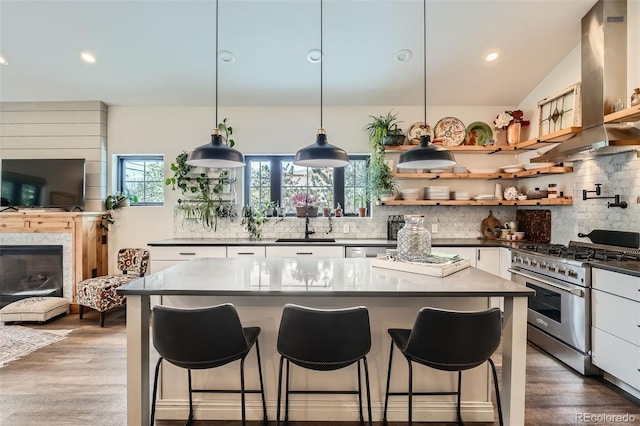kitchen featuring backsplash, island exhaust hood, dark countertops, and stainless steel stove