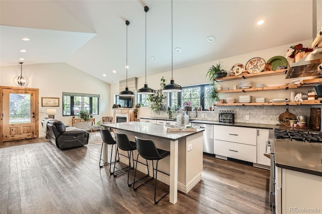 kitchen featuring a breakfast bar area, backsplash, dark wood-style flooring, dark countertops, and white cabinetry