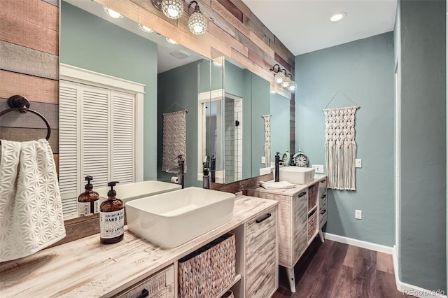 bathroom with vanity, baseboards, recessed lighting, and wood finished floors