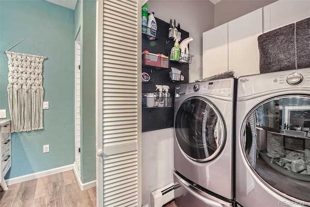 laundry room featuring laundry area, baseboards, wood finished floors, a baseboard radiator, and washer and clothes dryer