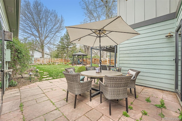 view of patio with a fenced backyard, outdoor dining area, and a gazebo