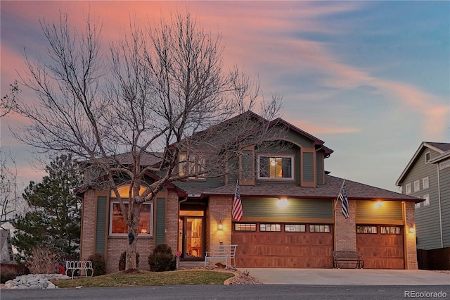 view of front of house with brick siding, concrete driveway, and a shingled roof