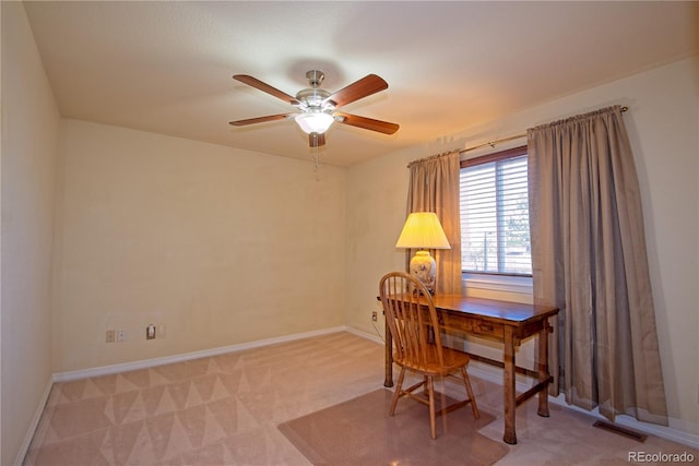 carpeted home office featuring ceiling fan