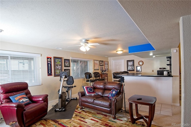 living room featuring ceiling fan and a textured ceiling