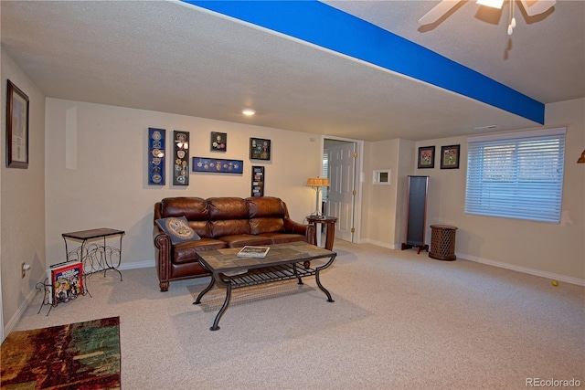 living room featuring ceiling fan, carpet floors, and a textured ceiling