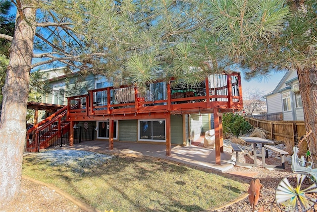 rear view of property with a wooden deck, a yard, and a patio area