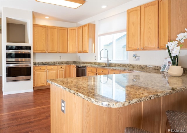 16873 Boreas Ct, Parker, CO 80134 - kitchen with dark wood-style floors, black dishwasher, a peninsula, light stone counters, and double oven