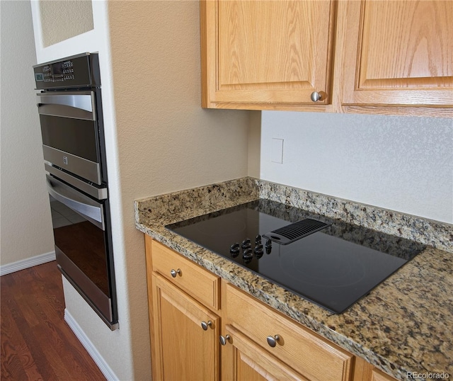 16873 Boreas Ct, Parker, CO 80134 - kitchen featuring black electric cooktop, dark wood-type flooring, stainless steel double oven, stone counters, and light brown cabinets
