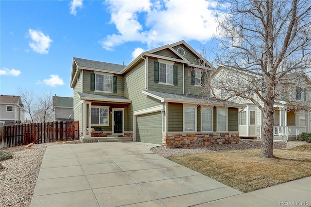 craftsman-style house with stone siding, a porch, fence, concrete driveway, and a garage