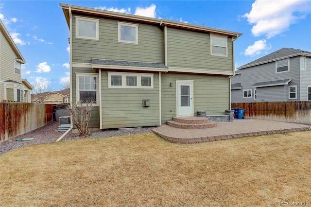 rear view of property with a fenced backyard, a patio area, and a yard