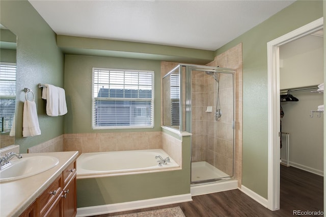 bathroom featuring vanity, a shower stall, a bath, and wood finished floors