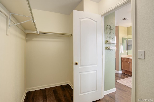 walk in closet featuring dark wood-type flooring and visible vents