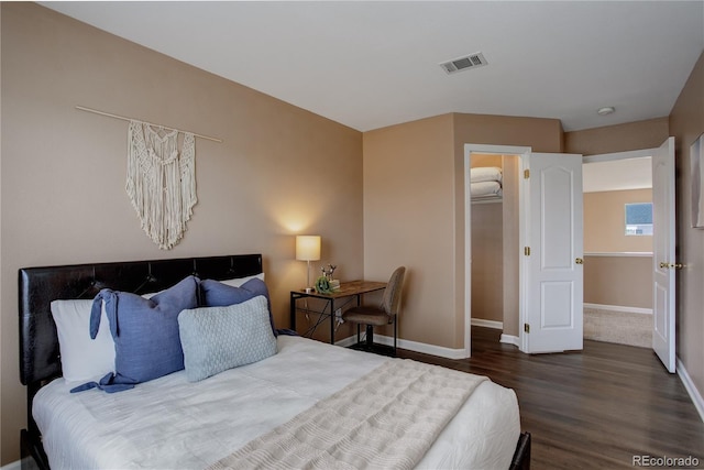 bedroom featuring visible vents, baseboards, and wood finished floors