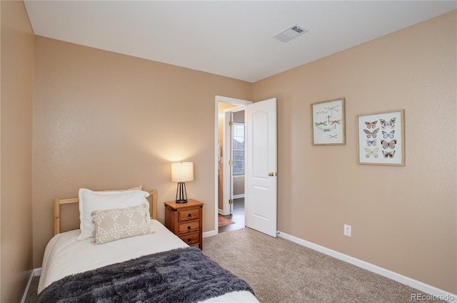 carpeted bedroom with visible vents and baseboards
