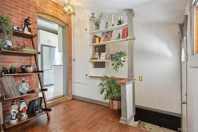 foyer featuring a chandelier, baseboards, and wood finished floors