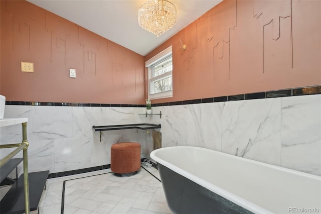 full bathroom with a soaking tub, vaulted ceiling, and a chandelier