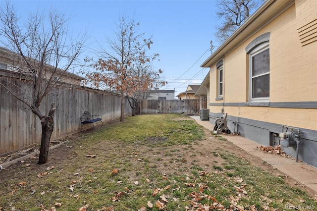 view of yard with central AC unit and a fenced backyard