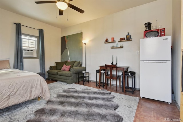 bedroom featuring baseboards and freestanding refrigerator