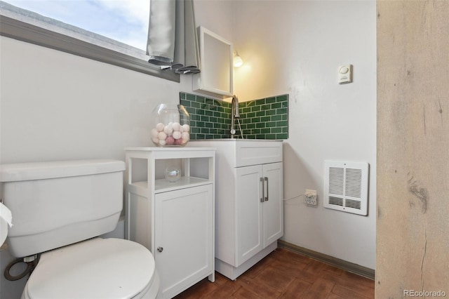 bathroom with tasteful backsplash, visible vents, baseboards, toilet, and wood finished floors