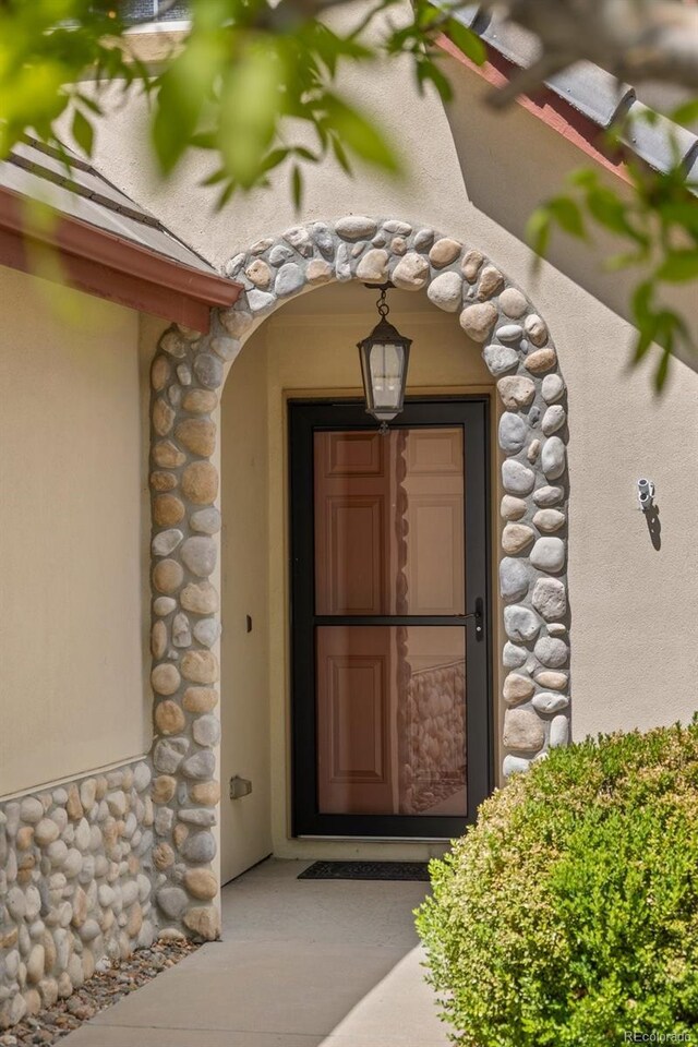 4194 Beautiful Cir, Castle Rock, CO 80109 - doorway to property with stone siding and stucco siding