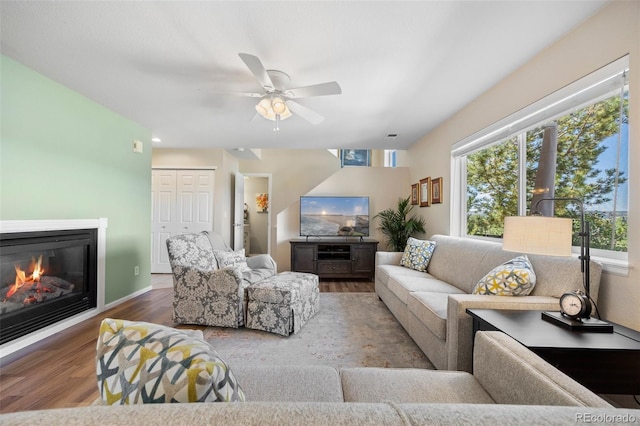 4194 Beautiful Cir, Castle Rock, CO 80109 - living area featuring wood finished floors, a ceiling fan, healthy amount of natural light, and a glass covered fireplace
