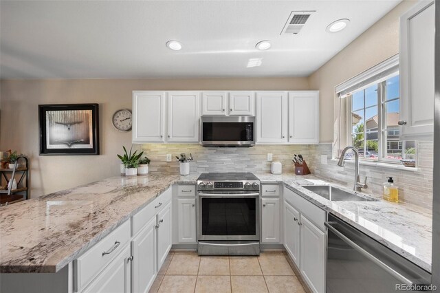 4194 Beautiful Cir, Castle Rock, CO 80109 - kitchen featuring appliances with stainless steel finishes, a sink, a peninsula, white cabinetry, and recessed lighting