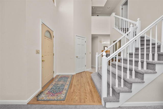 6868 Johnson St, Arvada, CO 80004 - foyer entrance featuring wood finished floors, stairway, baseboards, and a high ceiling
