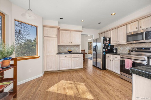 6868 Johnson St, Arvada, CO 80004 - kitchen with stainless steel appliances, dark countertops, backsplash, light wood-style floors, and recessed lighting