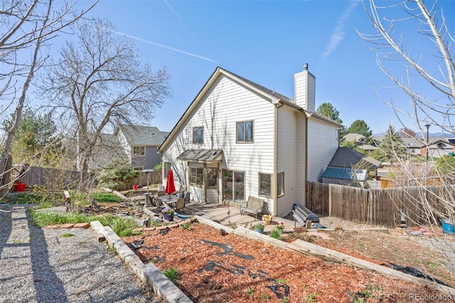 6868 Johnson St, Arvada, CO 80004 - back of property featuring a chimney, a fenced backyard, and a patio area