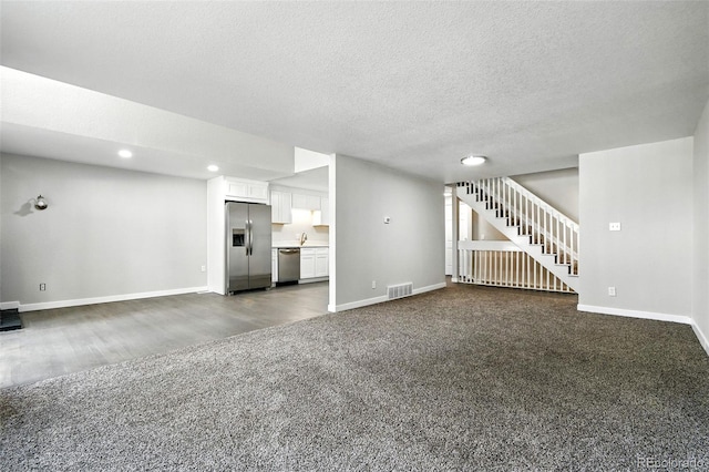 2976 S Parker Ct, Aurora, CO 80014 - unfurnished living room with dark carpet, recessed lighting, stairway, a textured ceiling, and dark wood finished floors