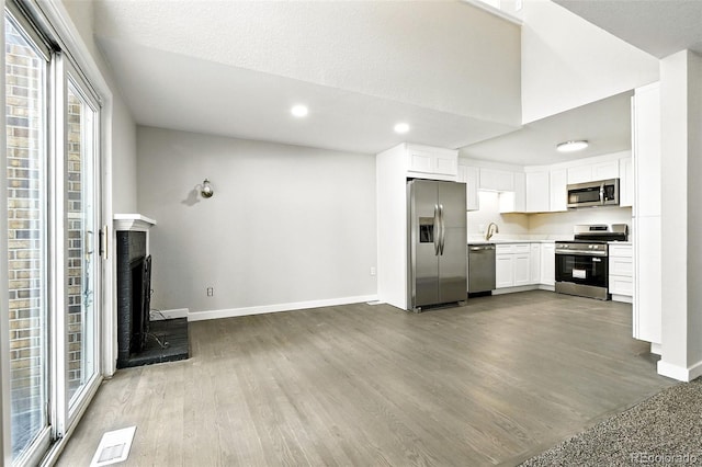 2976 S Parker Ct, Aurora, CO 80014 - unfurnished living room featuring wood finished floors, recessed lighting, and a brick fireplace